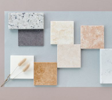 Luxury tile and stone samples in marble, quartzite, and porcelain arranged on a flat lay for a 30A remodel
