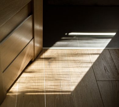 Luxury wood flooring in a 30A home with sunlight creating patterned shadows