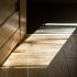 Luxury wood flooring in a 30A home with sunlight creating patterned shadows